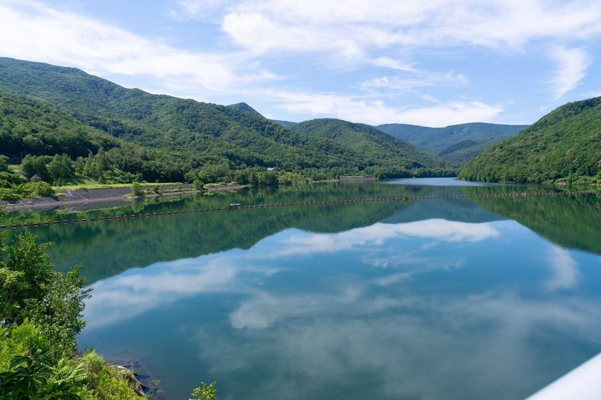 朝里水坝的湖面倒映着青山与白云
